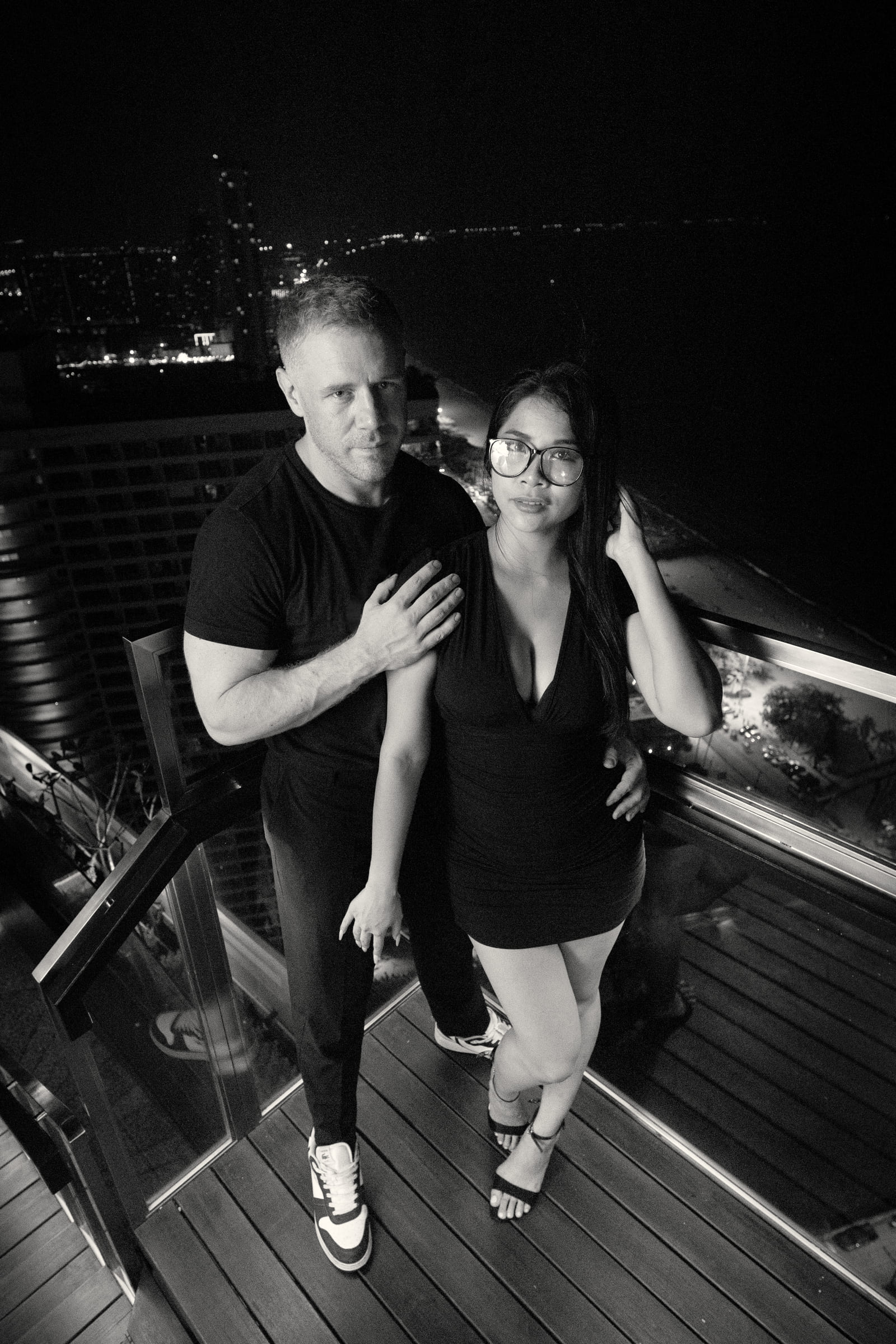 Tim and Paemi standing at a rooftop rail above Pattaya at night