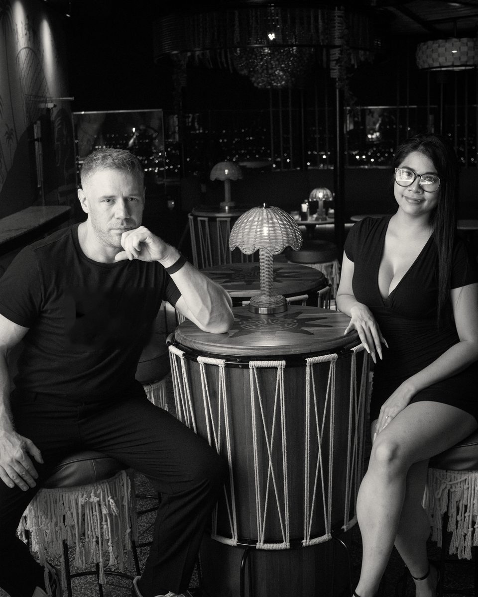 Tim and Paemi, the founders of TimPaemi, seated at a table in Pattaya